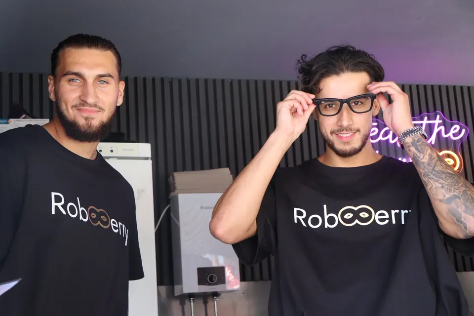 Das RobBerry-Team im Truck vor dem Neonschriftzug Steal the Glow