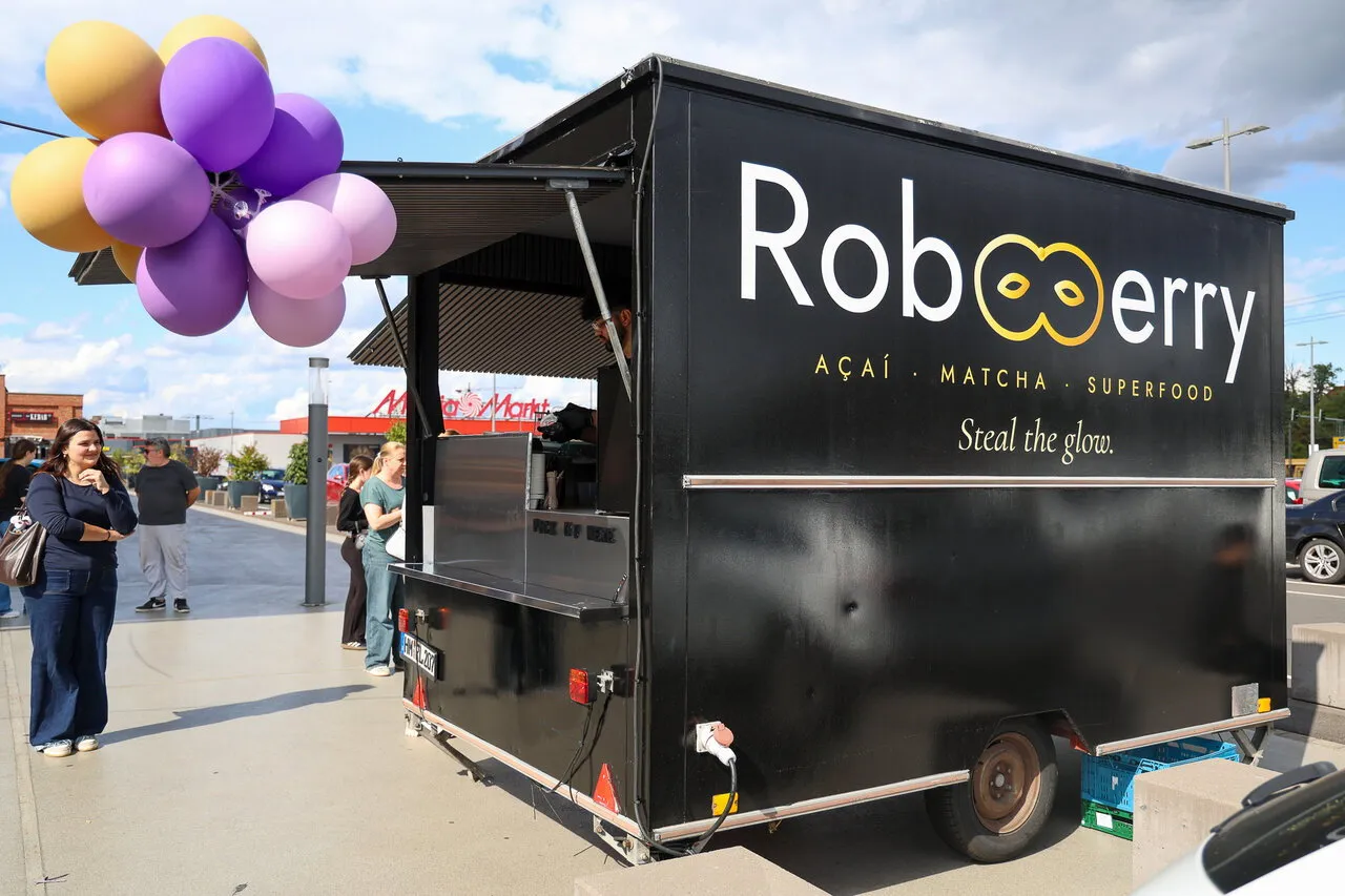 Der schwarze RobBerry-Anhänger mit lila-goldenen Ballons am Eröffnungstag vor dem Emaillierwerk